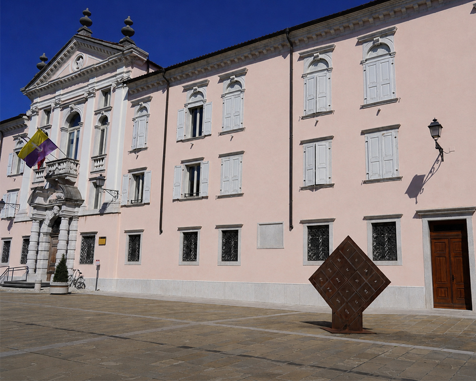 Immagine dell'ingresso della Galleria Spazzapan in una giornata assolata, con vista parziale della piazza antistante.